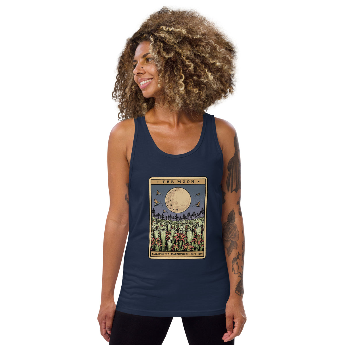 Woman wearing a navy tank top with a graphic design on a white background