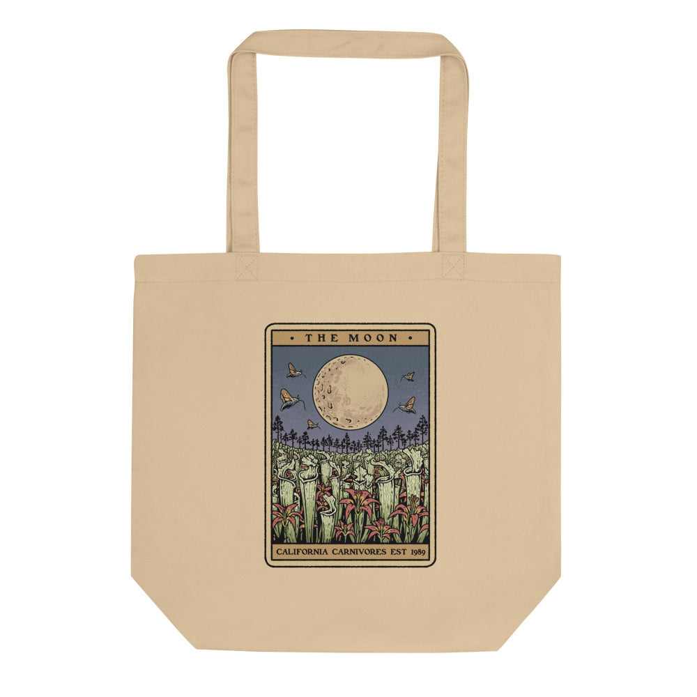 Beige tote bag with a graphic design of a moon and trees on a white background