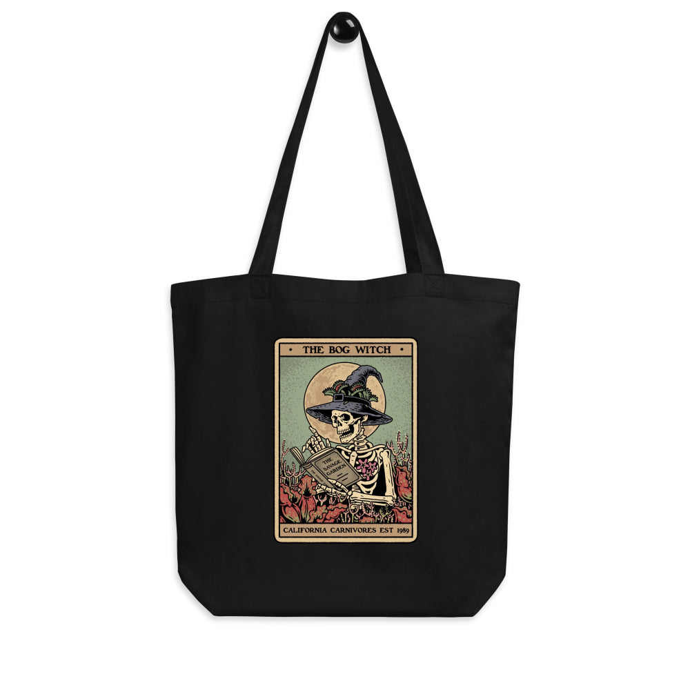 Black tote bag with a graphic design featuring a skeleton in a witch hat and text on a white background