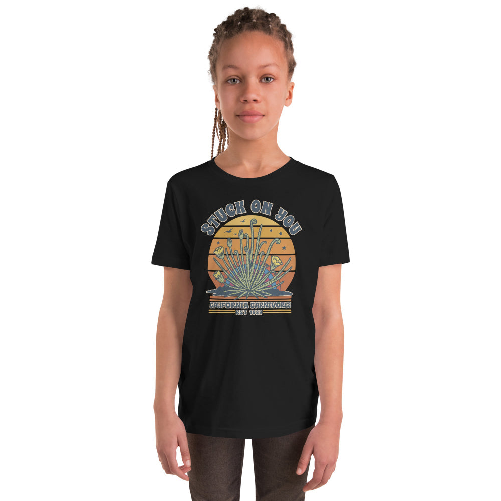 Child wearing a black t-shirt with a graphic design on a white background