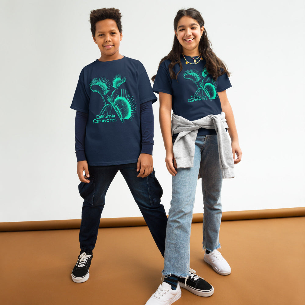 Two children wearing matching blue t-shirts with a logo on a white background