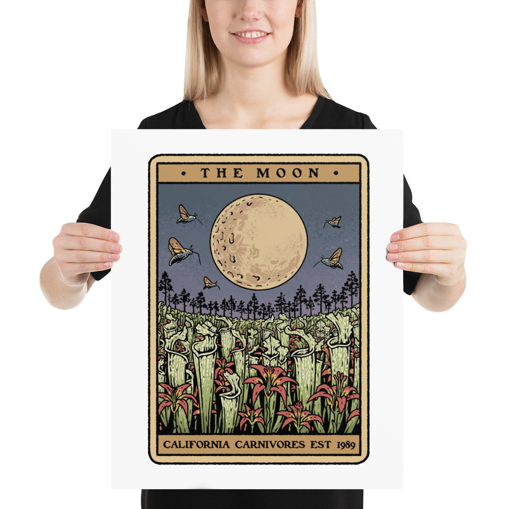 Person holding a framed artwork titled 'The Moon' by California Carnivores.