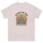 Ice grey t-shirt with a graphic design featuring text and plant-like elements on a white background