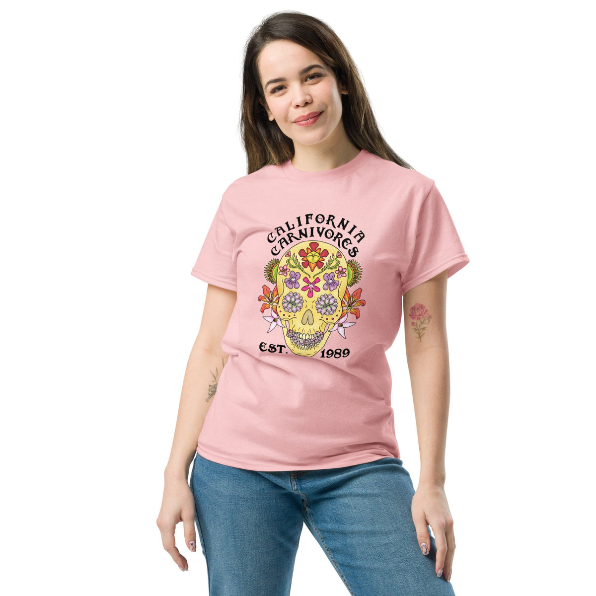 Woman wearing a pink t-shirt with a colorful skull design and text on a white background