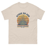 Beige t-shirt with graphic design and text on a white background