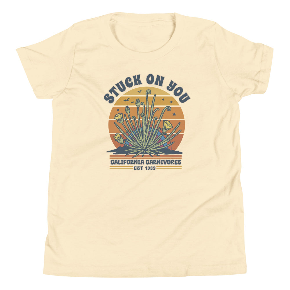 Beige t-shirt with a graphic design featuring text and plant illustration on a white background