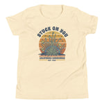 Beige t-shirt with a graphic design featuring text and plant illustration on a white background