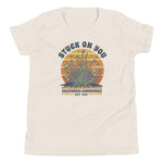 Sand colored t-shirt with graphic design and text on a white background