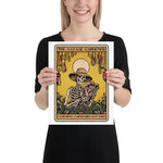 Person holding a poster titled 'The Savage Gardener' with a skeleton design.