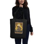 Person holding a black tote bag with a colorful design on a white background