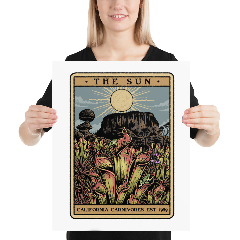 Person holding a framed artwork titled 'The Sun' by California Carnivores.