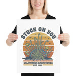 Person holding a poster with a desert plant design and text.