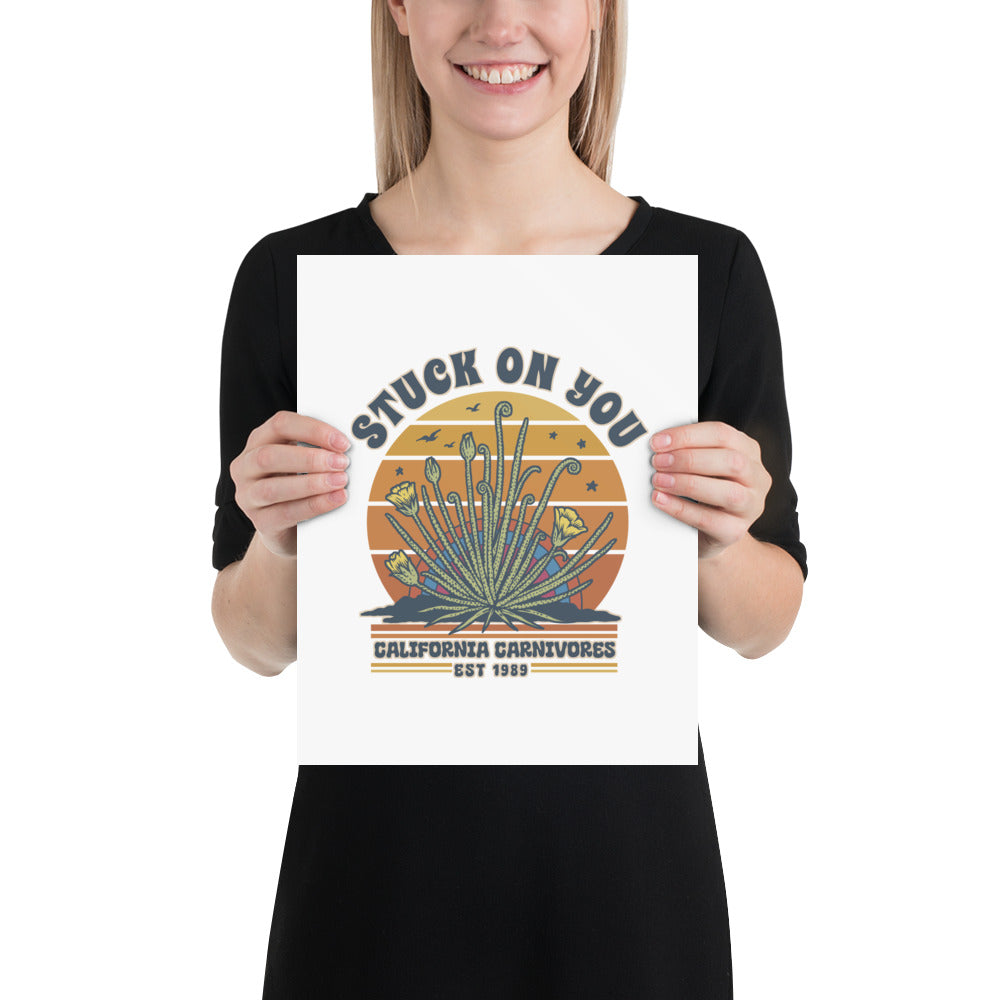 Person holding a poster with a graphic design of cacti and text.