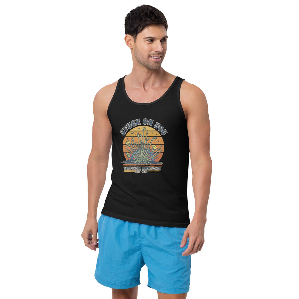 Man wearing a black tank top with a colorful graphic and blue shorts on a white background