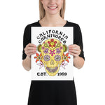 Person holding a poster with a colorful skull design and 'California Carnivores' text.