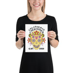 Person holding a poster with a colorful skull design and 'California Carnivores' text.