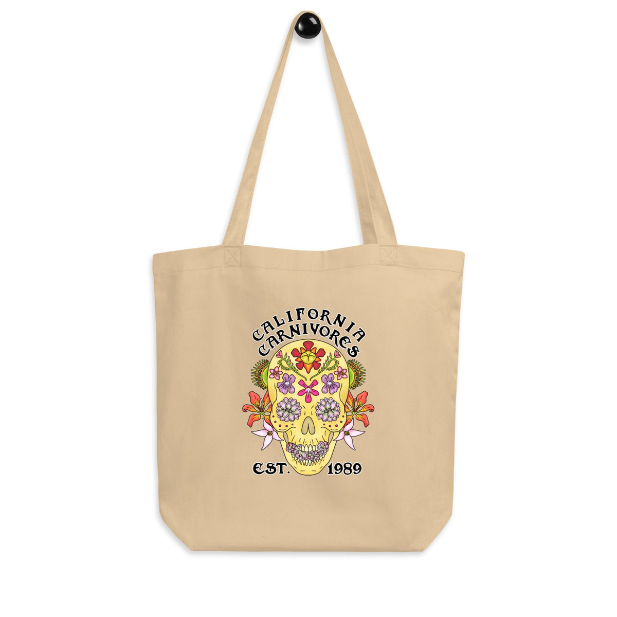 Beige tote bag with a colorful skull design and 'California Carnivores' text on a white background