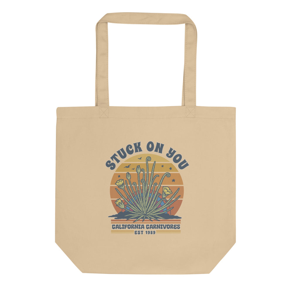 Beige tote bag with 'Stuck on You' graphic design on a white background