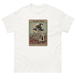 White t-shirt with a graphic of a skeleton in a witch hat and cape, sitting on a card with text 'The Bog Witch' on a white background.