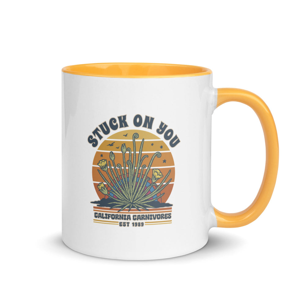 White mug with yellow handle and interior, featuring a graphic design and text.
