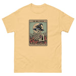 Yellow t-shirt with a graphic of a skeleton in a witch hat and cape, sitting on a card titled 'The Bog Witch'.